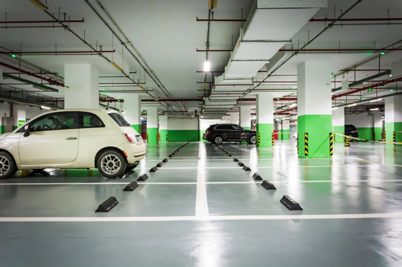 A parking space with 3 cars parked at a good distance from each other