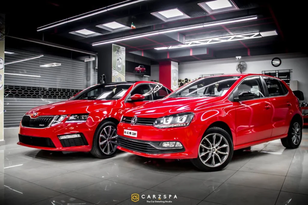 two red cars parked inside an automobile business outlet