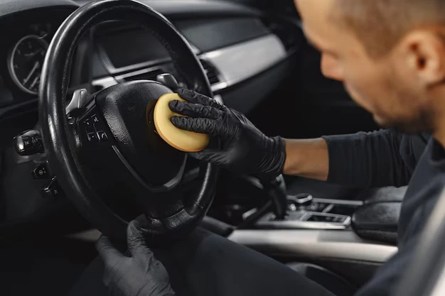 Worker cleaning car's steering