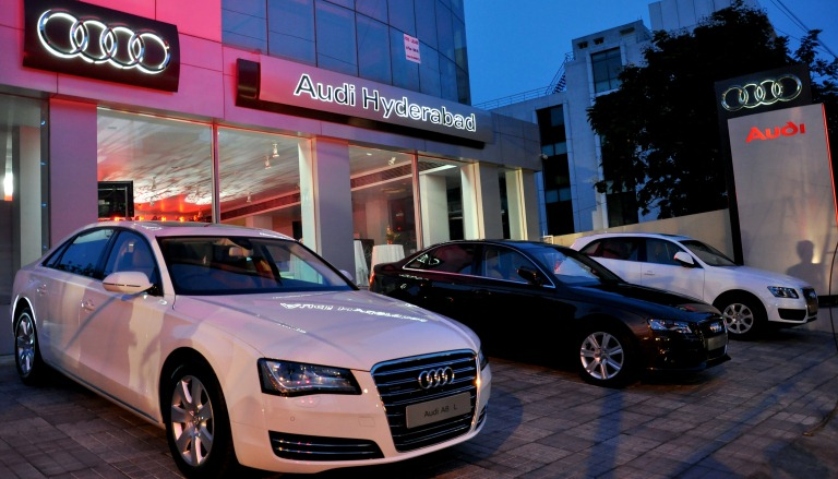 White and black coloured sedans lay parked outside an Audi Hyderabad car dealership