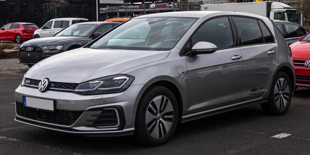 A Volkswagen Golf GTi, parked in a parking lot of a dealership amidst other cars