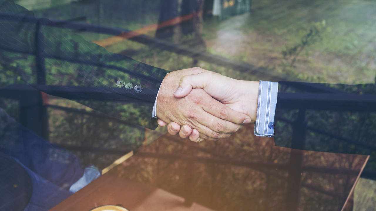 image of two hands of men dressed in formals shaking hands, to signify a deal being done